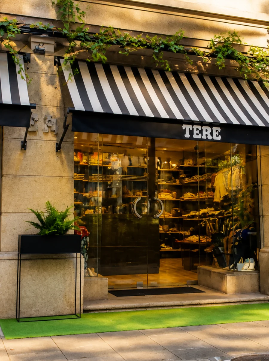 Fachada de la boutique Tere Moda con sus toldos de rayas y el rótulo TERE sobre la entrada.